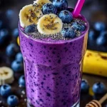 Banana-Blueberry Smoothie in a glass with fresh bananas and blueberries