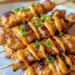 Plate of Bang Bang Chicken Skewers garnished with herbs and spices
