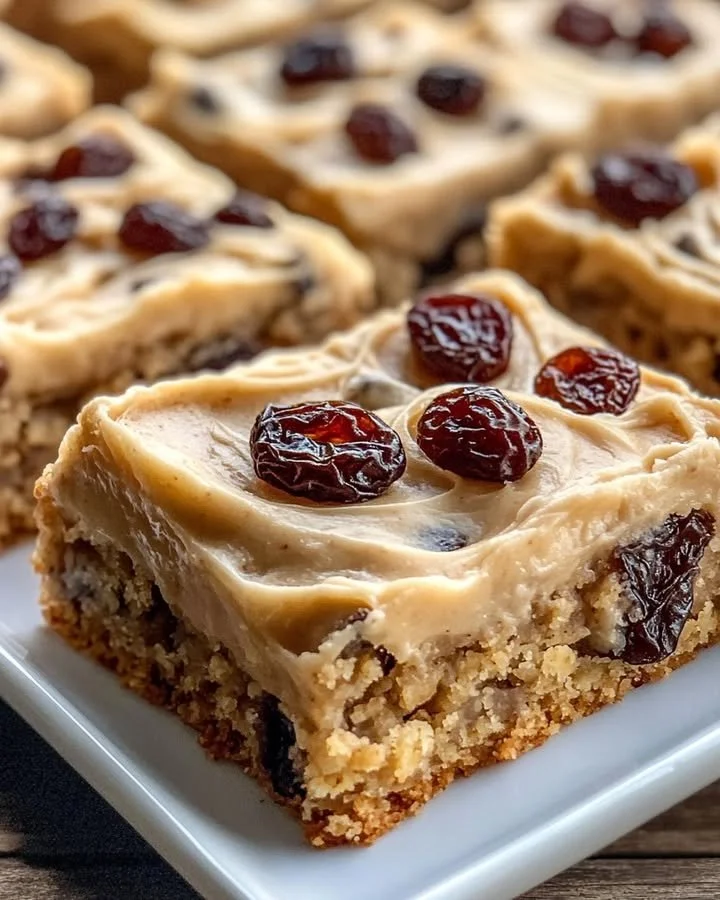 Brown butter oatmeal raisin cookie bars with raisins and oats on a wooden table