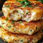 Cheesy tuna melt patties served on a plate with fresh herbs