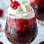 Chilled Cherry Rum Slushie in a glass, garnished with cherries and ice