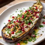 Deconstructed Baba Ghanoush platter featuring tahini, pomegranate, and pine nuts
