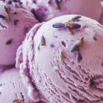 Delicious honey lavender ice cream in a bowl, garnished with lavender flowers.