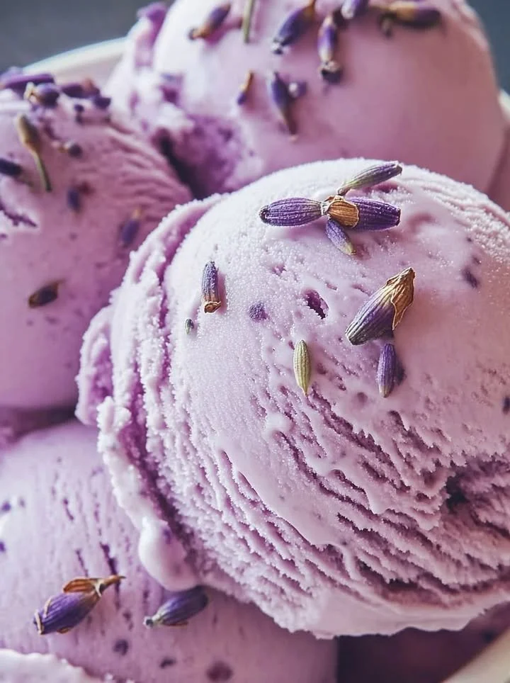 Delicious honey lavender ice cream in a bowl, garnished with lavender flowers.