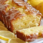 Slice of homemade lemon drizzle cake with a glossy lemon glaze