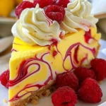 Slice of luscious lemon raspberry swirl cheesecake with raspberry garnish