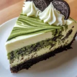 Slice of Matcha Oreo Swirl Cheesecake with a green tea swirl and Oreo crust