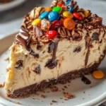 Delicious no-bake M&M Snickers cheesecake topped with colorful candies.