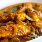 Plate of pickled fish with caramelized onions garnished with herbs