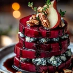 Roasted Beet and Blue Cheese Towers arranged on a plate, garnished with herbs.