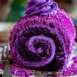 Sliced purple velvet cake roll with cream cheese filling on a white plate