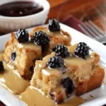 Wild berry bread pudding served with orange sauce in a bowl